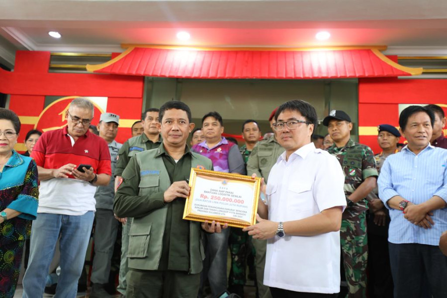 Kepala BNPB Letjen TNI Suharyanto (kiri) memberikan bantuan dana siap pakai operasional kepada Pemerintah Kota Manado, Sabtu (28/1).
