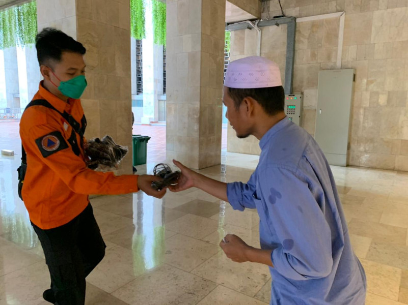 Pembagian masker gratis kepada umat muslim yang melakukan ibadah ramadan di Masjid Istiqlal, Jakarta Pusat, Kamis (7/4).
