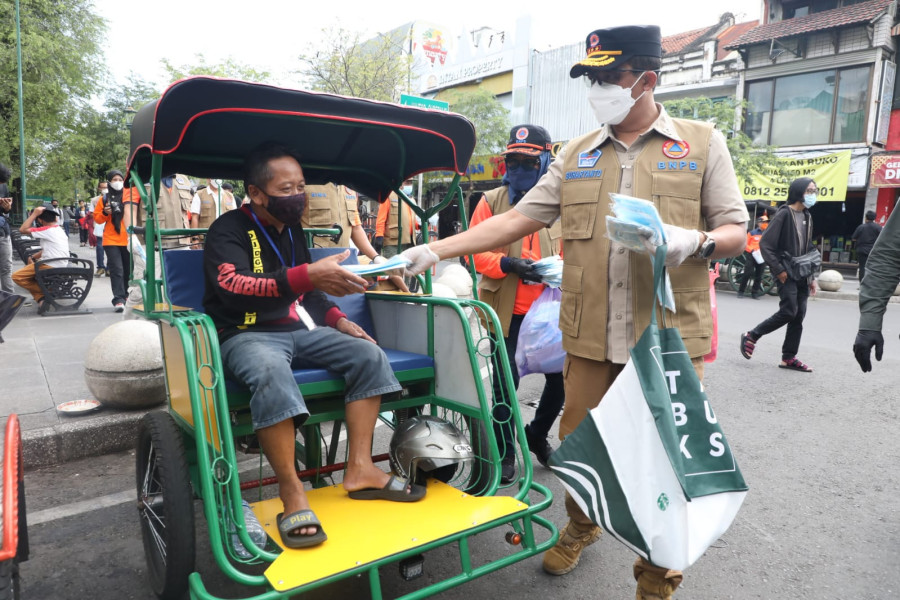 Kepala BNPB Letjen TNI Suharyanto memberikan masker kepada tukang becak yang berada di kisaran Malioboro, Yogyakarta, Minggu (27/2).