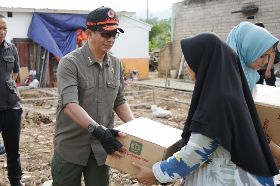 Kepala Badan Nasional Penanggulangan Bencana Letjen TNI Suharyanto (kiri) menyerahkan bantuan logistik kepada warga di Kp Cipetir, Desa Ciwalen, Warung Kondang, Cianjur, Jawa Barat, Jumat (6/1).