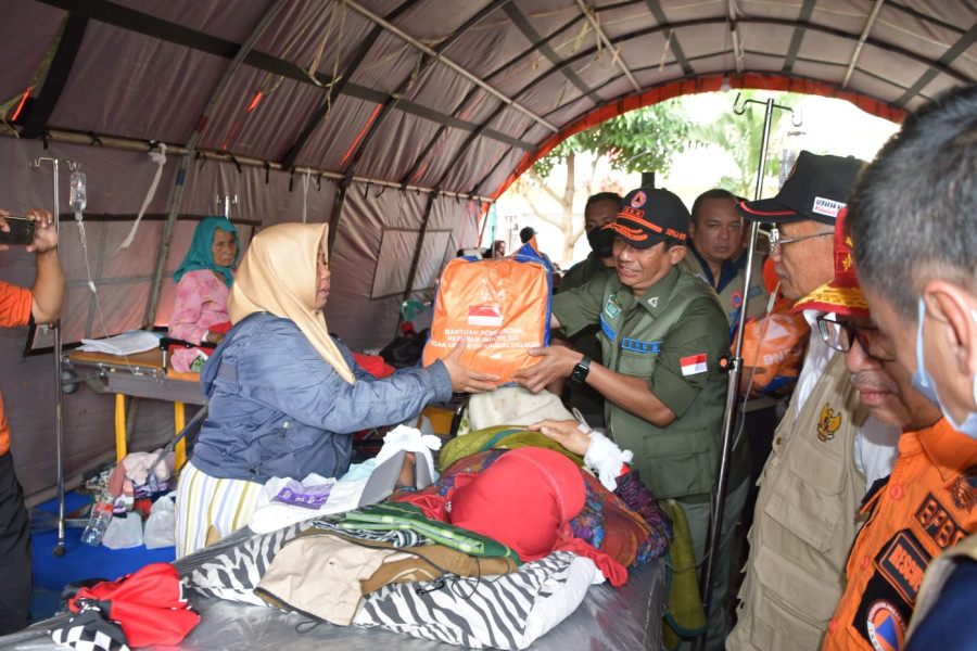 Kepala BNPB Letjen TNI Suharyanto (rompi hijau) memberikan bantuan bagi para pasien di rumah sakit lapangan di Kabupaten Cianjur, Jawa Barat, Selasa (22/11).