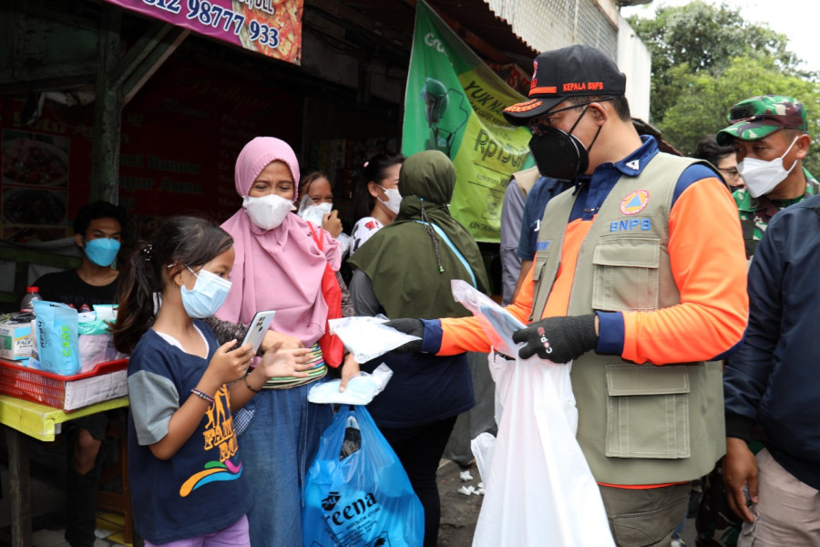 Kepala BNPB sekaligus Ketua Satgas Penanganan COVID-19 Letjen TNI Suharyanto (memakai rompi dan topi) membagikan masker kepada masyarakat di kawasan Cideng, Jakarta Pusat, pada Sabtu (12/2) sore.