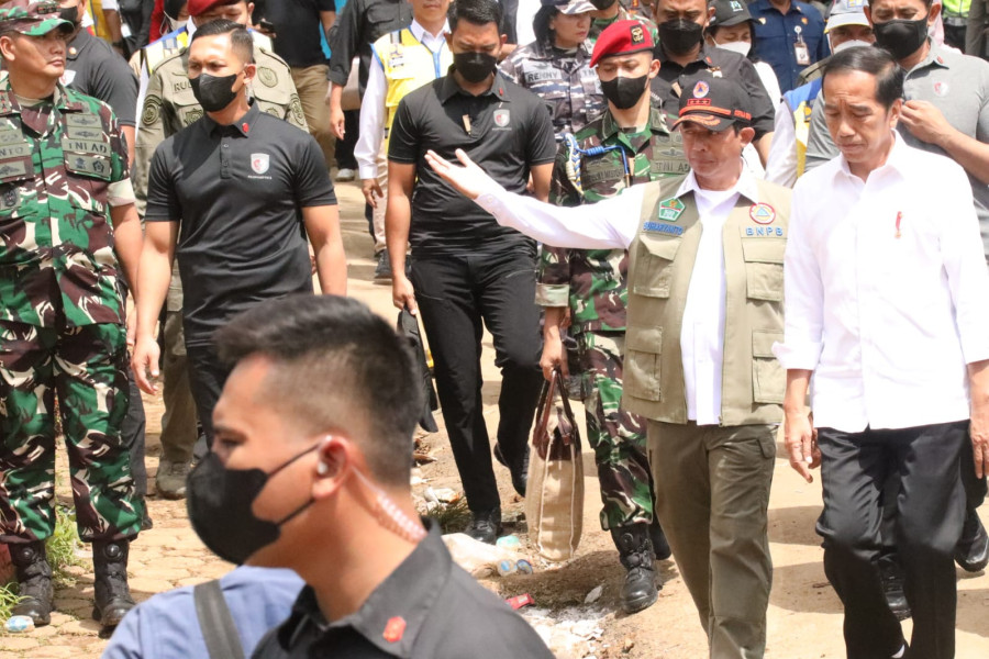 Kepala BNPB Letjen TNI Suharyanto (kemeja putih dengan rompi) memberikan penjelasan perkembangan penanganan gempa Cianjur kepada Presiden Joko Widodo (kemeja putih) di Desa Cijendil, Kabupaten Cianjur, Jawa Barat pada Kamis (24/11).