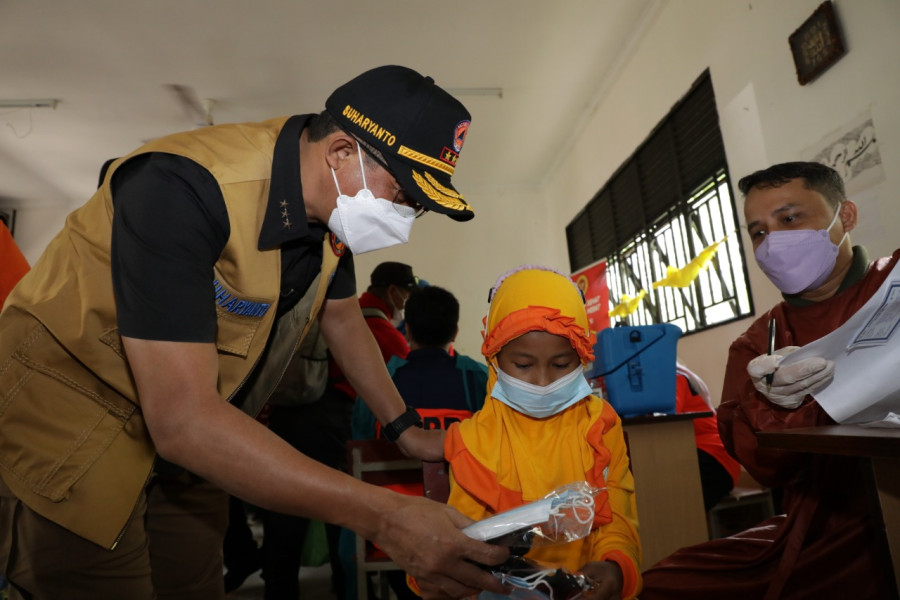 Kepala BNPB sekaligus Ketua Satgas Penanganan Covid-19 Letjen TNI Suharyanto (kiri) memberikan masker gratis kepada seorang siswa yang telah menerima vaksin Covid-19 di SD 009 Sei Beduk, Kota Batam, Kepulauan Riau, Kamis (24/3).