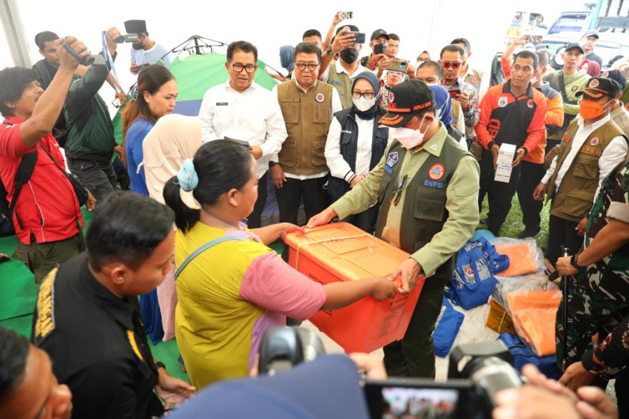Kepala BNPB Letjen TNI Suharyanto (rompi hijau) menyerahkan bantuan kepada warga pengungsian di Stadion Manakarra, Mamuju, Sulawesi Barat, Kamis (9/6).