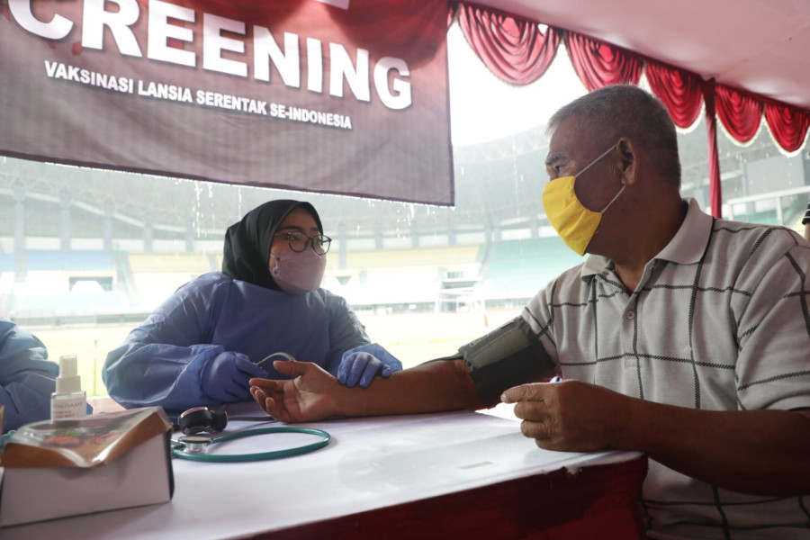 Tenaga kesehatan sedang melakukan pemeriksaan kesehatan sebelum memberikan vaksin kepada peserta Vaksinasi Serentak di Stadion Patriot Candrabhaga, Bekasi, Jawa Barat, Selasa (8/2).