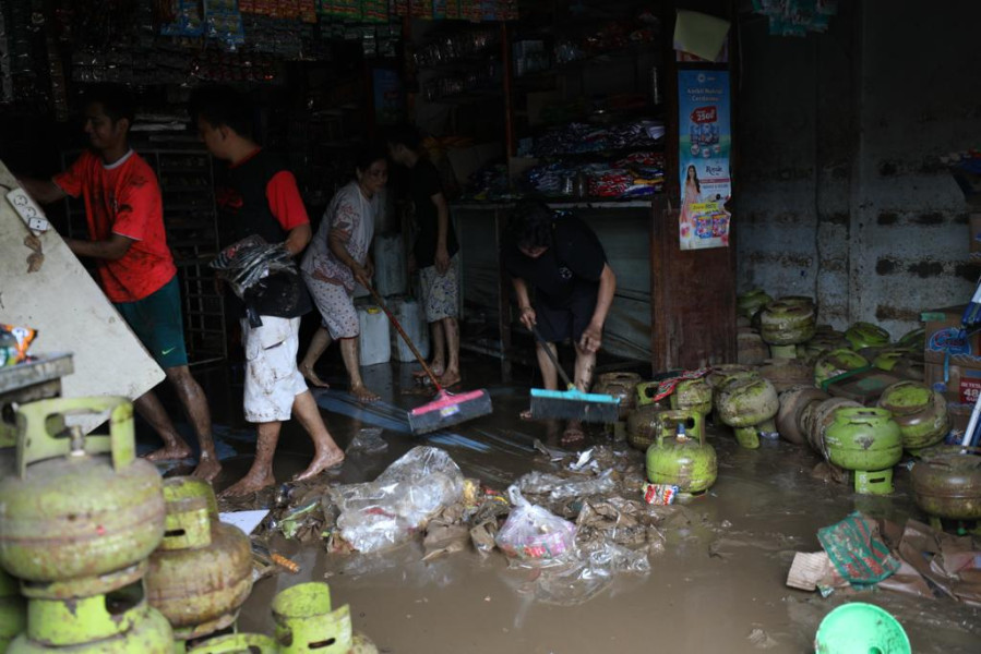Sejumlah warga berusaha menyelamatkan beberapa jenis produk yang terdampak banjir di sebuah toko retail di Jalan Raya Bailang, Lingkungan 1, Kelurahan Bailang, Kecamatan Bunaken, Kota Manado, Sulawesi Utara, Sabtu (28/1).