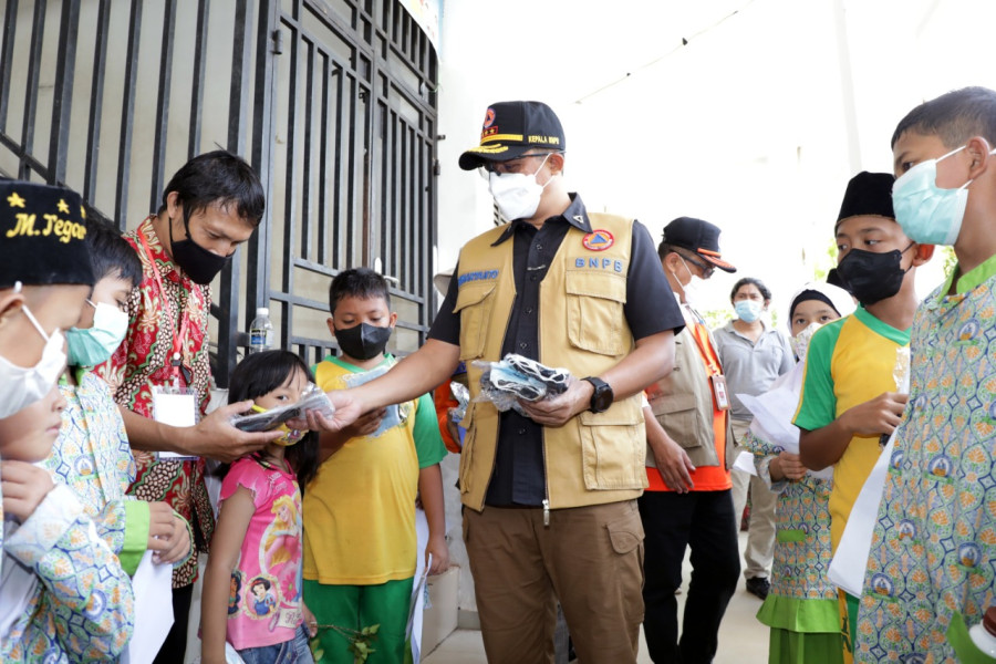 Kepala BNPB sekaligus Ketua Satgas Penanganan Covid-19 Letjen TNI Suharyanto (tengah) memberikan masker gratis kepada peserta vaksin di SD 009 Sei Beduk, Kota Batam, Kepulauan Riau, Kamis (24/3).