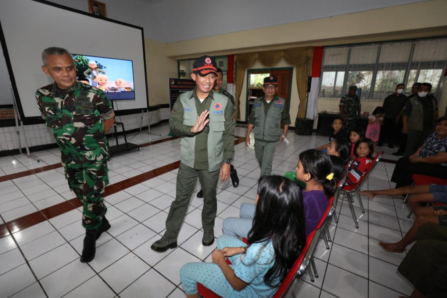 Kepala BNPB Letjen TNI Suharyanto (tengah dengan rompi hijau dan topi) menyapa anak-anak di lokasi pengungsian warga terdampak banjir di Kota Manado, Sulawesi Utara, Sabtu (28/1).