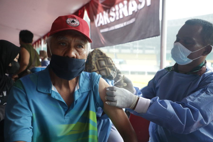 Tenaga kesehatan sedang melakukan penyuntikan kepada peserta yang dinyatakan sehat untuk mendapatkan vaksin saat pelaksanaan Vaksinasi Serentak di Stadion Patriot Candrabhaga, Bekasi, Jawa Barat, Selasa (8/2).