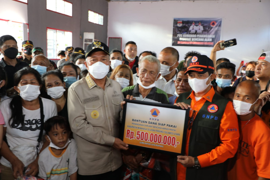 Kepala BNPB Letjen TNI Suharyanto, S.Sos., M.M. (menggunakan baju orange dan rompi) menyerahkan bantuan Dana Siap Pakai untuk Penanganan Darurat Bencana Abrasi Pantai Minahasa Selatan, Jumat (17/6).