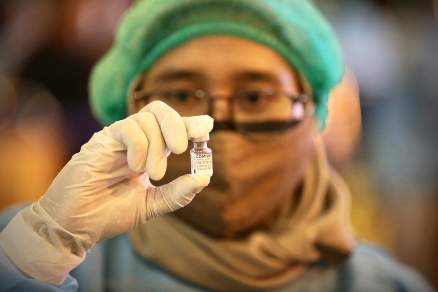 Vaksinator menunjukkan vial vaksin pfizer yang digunakan dalam vaksinasi lanjutan (booster) serentak di Hotel Bumi Wiyata, Kota Depok, Jawa Barat, Kamis (3/2).