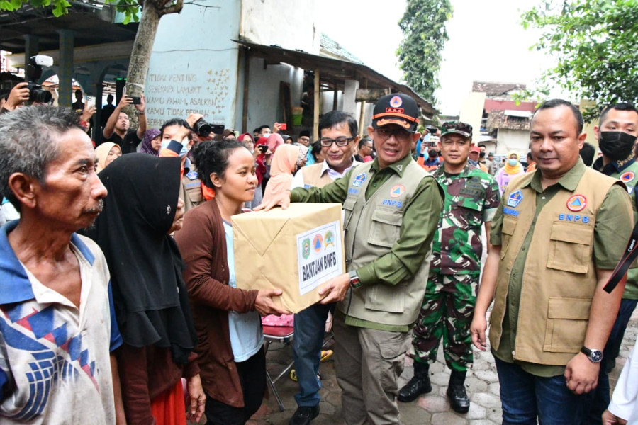 Kepala BNPB Letjen TNI Suharyanto (kemeja hijau dengan rompi) memberikan simbolis dukungan logistik  pemenuhan kebutuhan sehari-hari kepada warga terdampak banjir di Trenggalek, Jawa Timur, Kamis (20/10).
