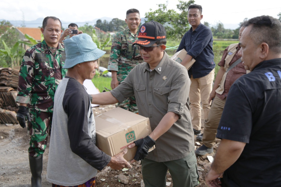 Kepala Badan Nasional Penanggulangan Bencana Letjen TNI Suharyanto (topi hitam) menyerahkan bantuan logistik kepada warga di Kp Cipetir, Desa Ciwalen, Warung Kondang, Cianjur, Jawa Barat, Jumat (6/1).