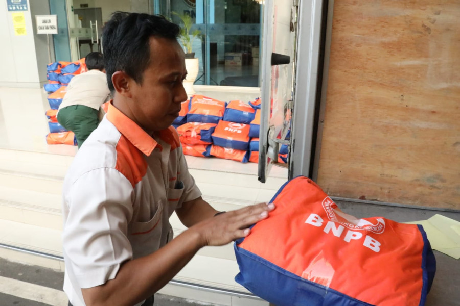 Petugas BNPB sedang mempersiapkan bantuan logistik yang akan dikirimkan menuju lokasi terdampak gempa M5,6 Kabupaten Cianjur, Senin (21/11).