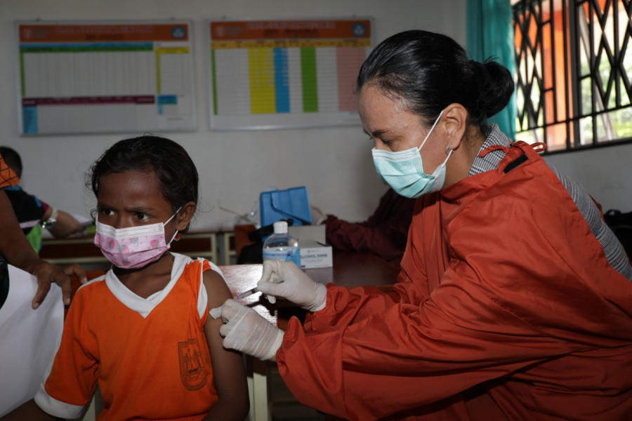Vaksinator menyuntikkan vaksin Covid-19 kepada seorang siswa di SD 02 Juara, Kota Batam, Kepulauan Riau, Kamis (24/3).