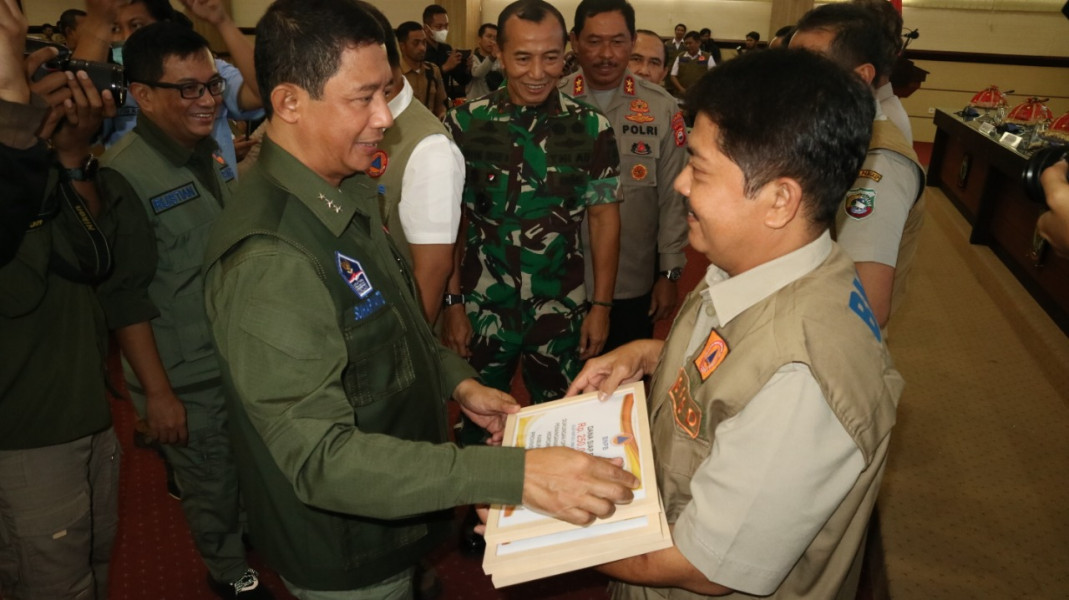 Kepala BNPB Letjen TNI Suharyanto (kiri) memberikan bantuan dana siap pakai kepada Pemerintah Provinsi Sulawesi Selatan dan 14 Kabupaten/Kota yang terdampak bencana hidrometeorologi, Senin (9/1).