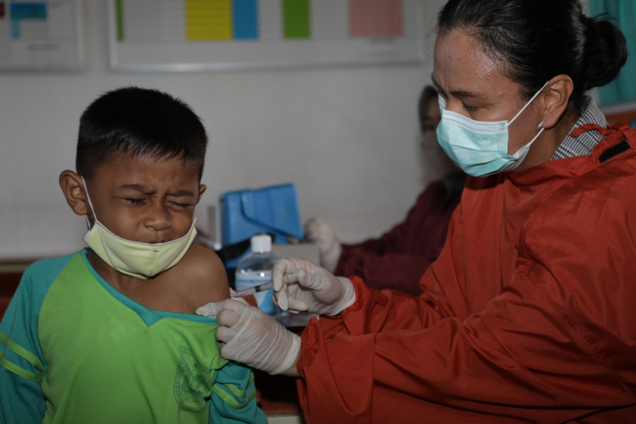 Vaksinator menyuntikkan vaksin Covid-19 kepada seorang siswa di SD 009 Sei Beduk, Kota Batam, Kepulauan Riau, Kamis (24/3).
