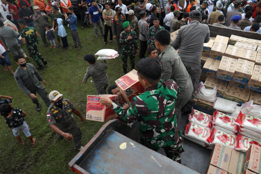 Anggota TNI dibantu Satpol PP dan warga menurunkan beberapa bantuan logistik dan permakanan bagi para pengungsi di Stadion Manakarra, Mamuju, Sulawesi Barat, Kamis (9/6).