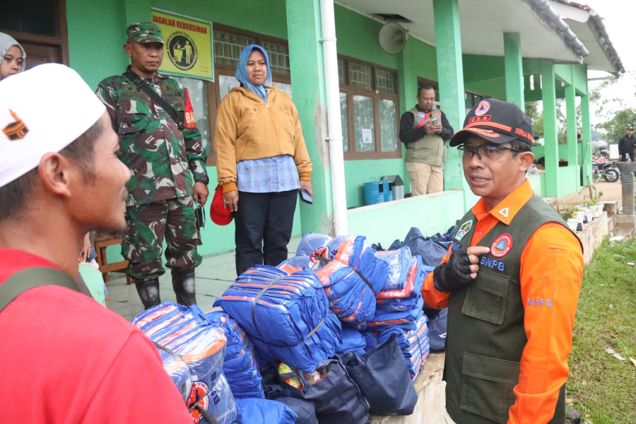 Kepala BNPB Letjen TNI Suharyanto (kemeja orange dengan rompi) berdiskusi dengan perwakilan pengungsi di Desa Mangunkarta, Kecamatan Cugenang, Kabupaten Cianjur, Jawa Barat pada Sabtu (26/11).